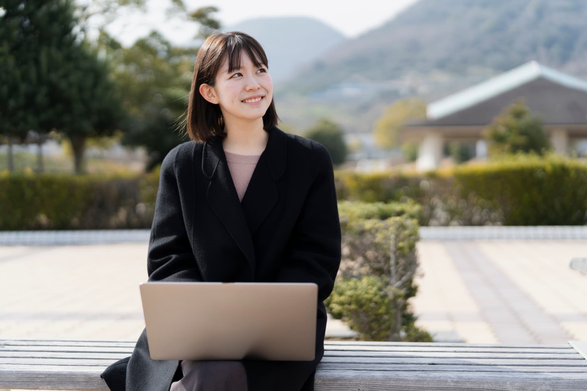 パソコンを膝に乗せる女性